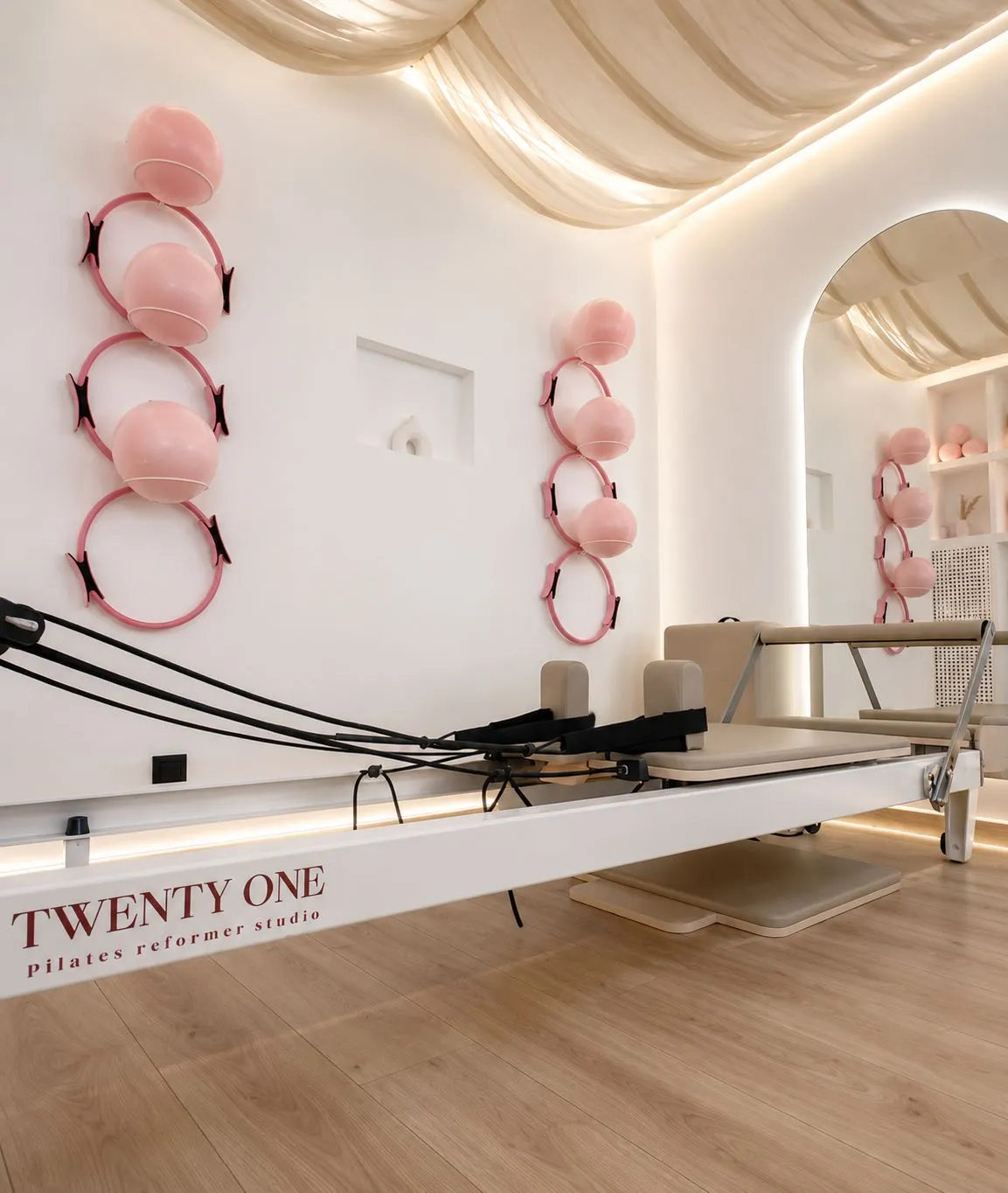 Un reformer blanc marqué Twenty One, devant le mur de ballons et cercles roses